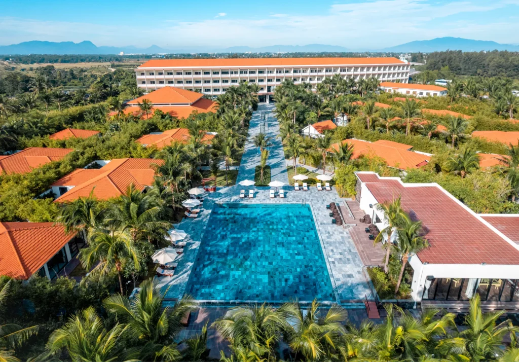Aerial view of Grandvrio Ocean Resort Danang beachfront with turquoise ocean and lush tropical gardens – hotel booking, beach resort deals & Vietnam travel deals on WingReserve.com