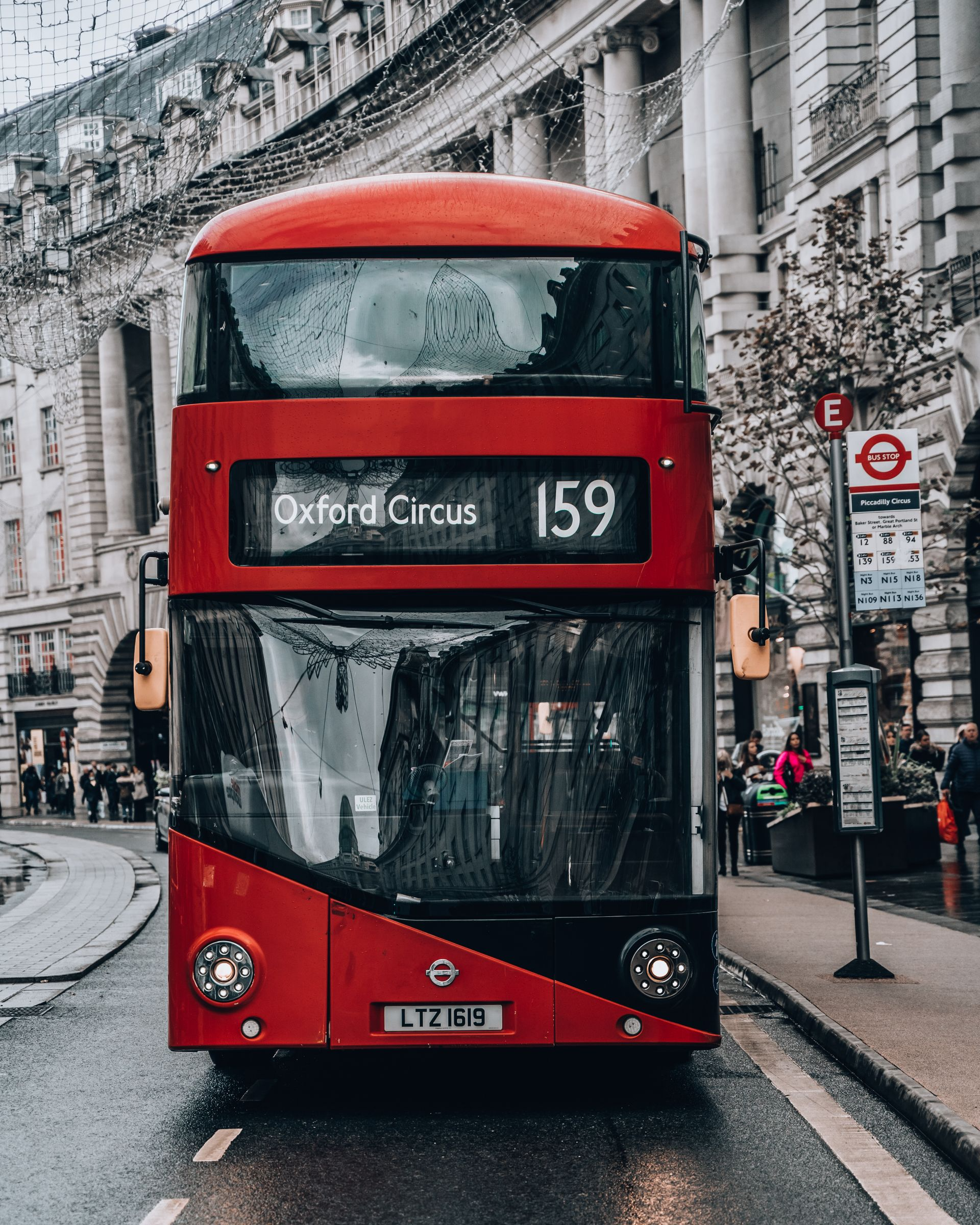 A busy shopping scene on Oxford Street in London with double-decker buses and pedestrians near the best family hotels in London Oxford street