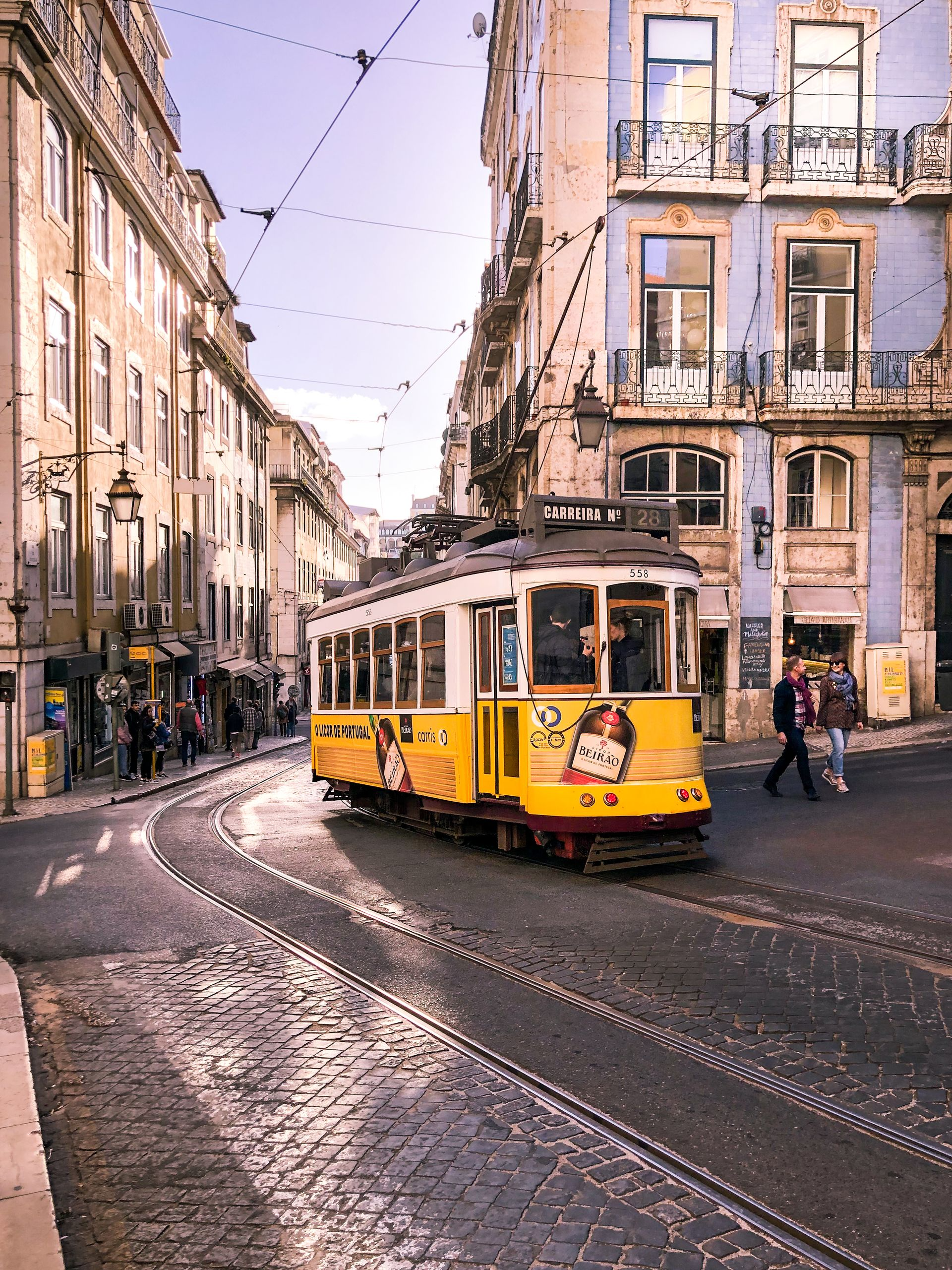 Charming yellow tram on the streets of Lisbon, capturing classic architecture and urban life