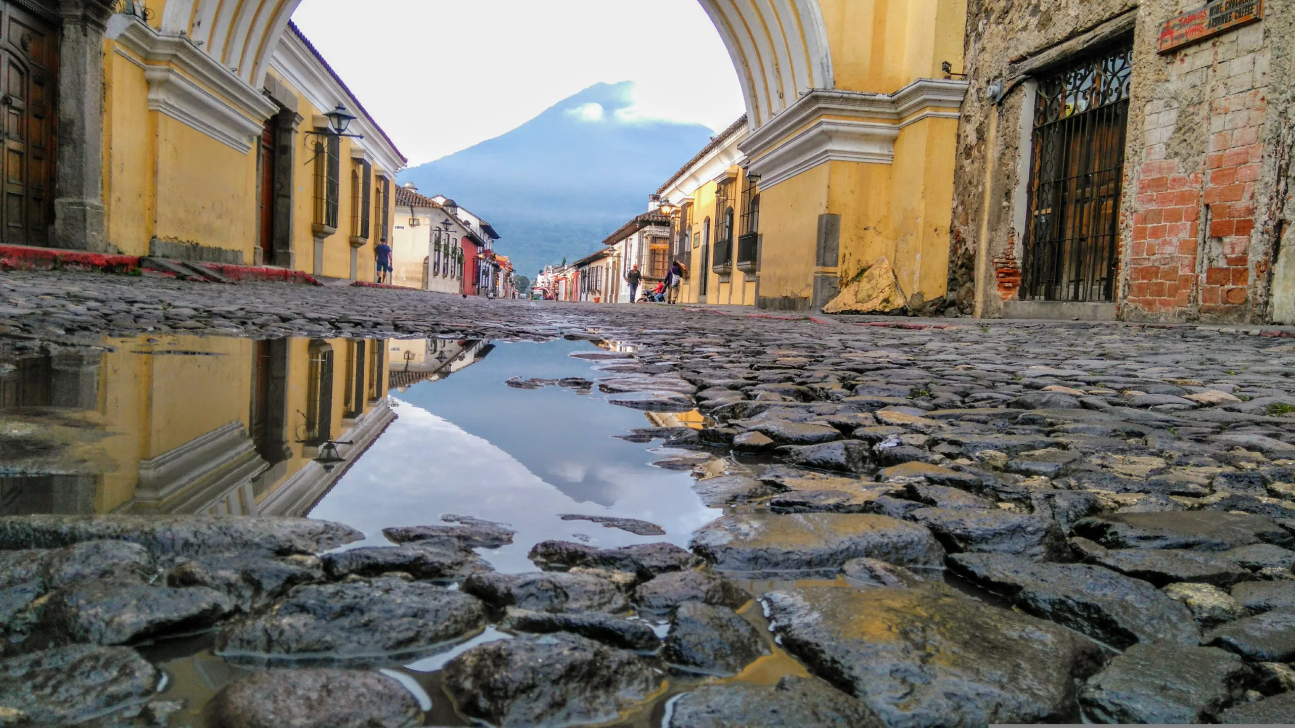 Colonial street in Antigua Guatemala with Volcán de Agua behind — cheap travel destination in Central America