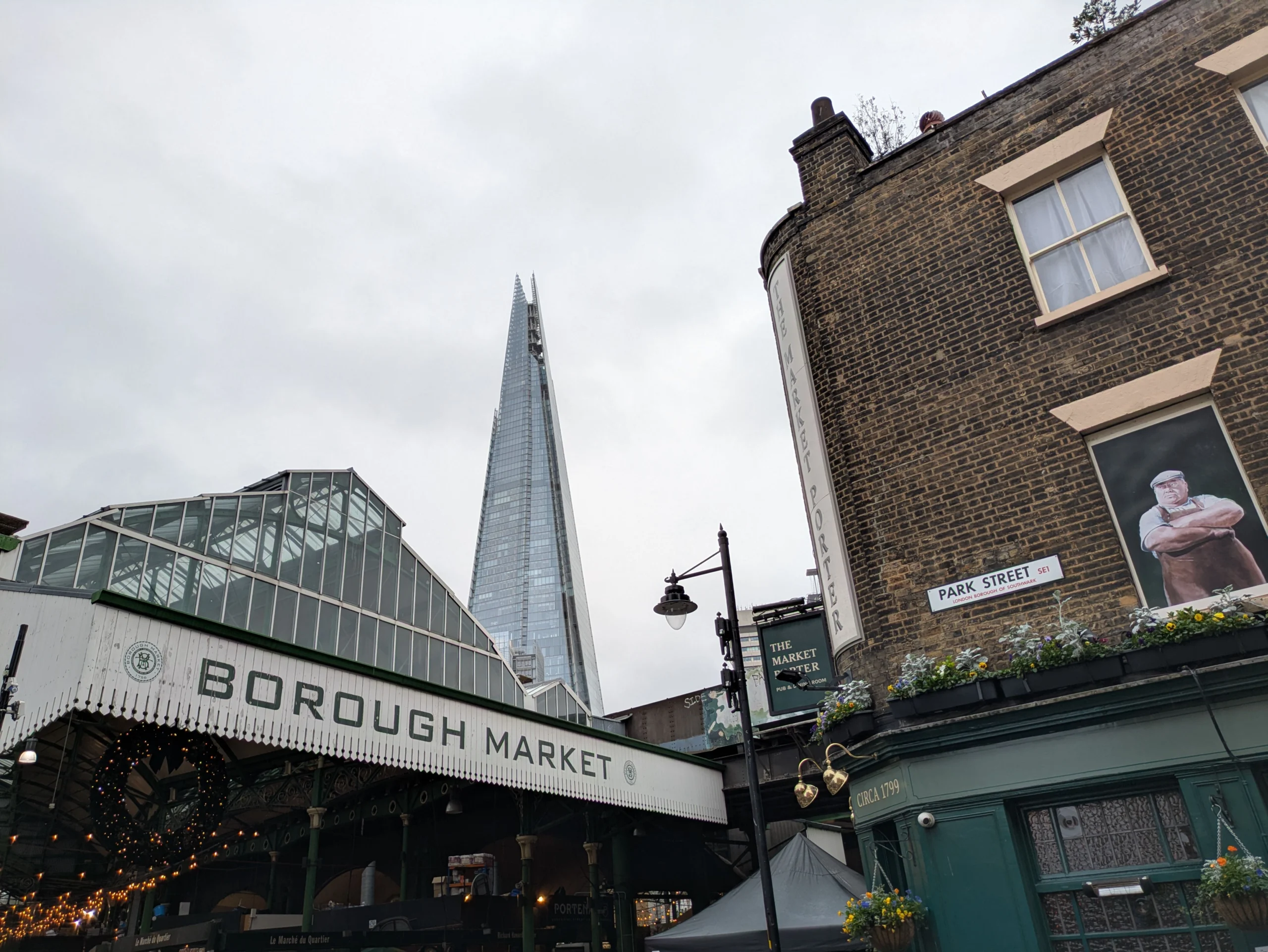 Borough Market entrance with its glass roof and The Shard behind, next to The Market Porter pub on Park Street, London
